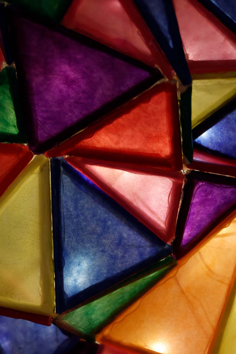 A close up of glowing colored triangles that make up the lamp